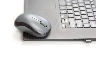 Beyaz bir masadaki dizüstü bilgisayarın yanında kablosuz fare. elektronik kişisel endüstri