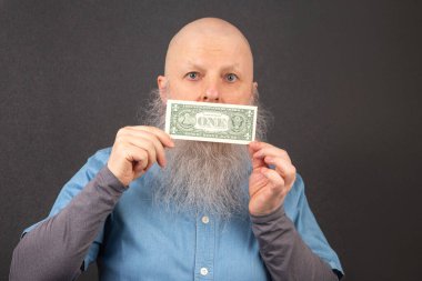 Büyük beyaz sakallı kel adam elinde bir dolar tutuyor. Finansal ekonomi konsepti. yoksulluk ve gıda krizi