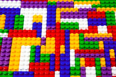 Renkli yapı bloklarının soyut arkaplan dokusu. İnşaatçının renkli plastik parçalarının arka planı. Renkli oyuncak yığınları..