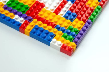 Renkli yapı bloklarının soyut arkaplan dokusu. İnşaatçının renkli plastik parçalarının arka planı. Renkli oyuncak yığınları..
