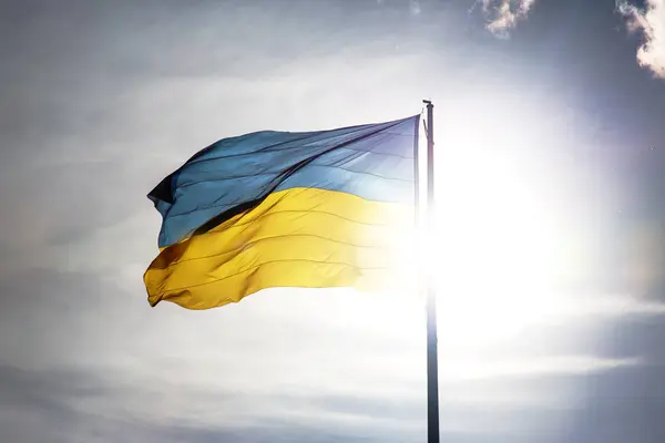 Ukrayna 'nın ulusal bayrağı güneş ve mavi gökyüzünün arka planına karşı. Vatanseverlik ve ulusal sembol