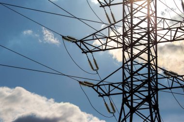 Elektrik gerilim kablolarına sahip yüksek voltaj kulesi bulutların arka planına yakın çekim izole eder. Enerji endüstrisi.
