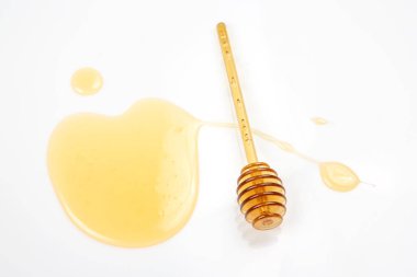 Beyaz arka planda taze bal dökülmüş kaşık. organik vitamin yiyeceği