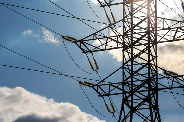 Elektrik gerilim kablolarına sahip yüksek voltaj kulesi bulutların arka planına yakın çekim izole eder. Enerji endüstrisi.