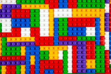 Renkli yapı bloklarının soyut arkaplan dokusu. İnşaatçının renkli plastik parçalarının arka planı. Renkli oyuncak yığınları..