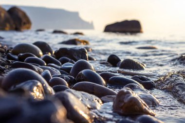 Taştan sahilde gün doğumu ve günbatımı. Doğadaki manzara