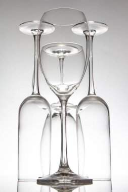 Uzun saplı beş boş şarap kadehinden oluşan sofistike bir düzenleme. Cilalı bir masaya yansıyor. Güzel bir yemek için mükemmel..