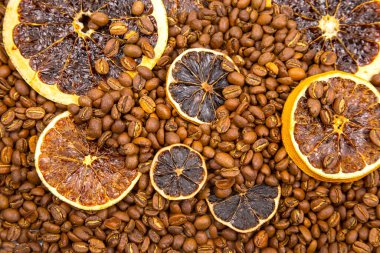 Sanatsal yemek fotoğrafçılığı, kavrulmuş kahve çekirdekleri denizinin üzerinde kurutulmuş turuncu tekerlekleri sergiliyor, doğal renk ve aromaları harmanlıyor. kahve aroması ve tat tanımlayıcıları