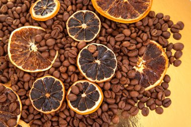 Sanatsal yemek fotoğrafçılığı, kavrulmuş kahve çekirdekleri denizinin üzerinde kurutulmuş turuncu tekerlekleri sergiliyor, doğal renk ve aromaları harmanlıyor. kahve aroması ve tat tanımlayıcıları