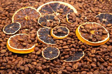 Kavrulmuş kahve çekirdeklerinin arasına yerleştirilmiş canlı bir portakal dilimleri sıcak, aromatik aromatik narenciye ve kahve dokuları oluşturur. kahve aroması ve tat tanımlayıcıları