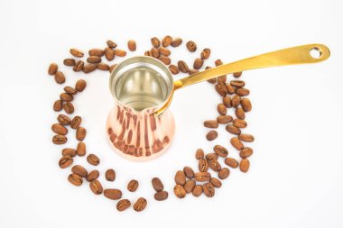 Pirinç saplı şık bakır kahve demliği minimalist beyaz arka planda kavrulmuş kahve çekirdekleri ile eşleştirilmiş kahve aşığı ve mutfak görselleri için harika..