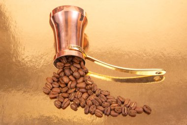 Işıl ışıl altın bir zemin üzerinde kavrulmuş kahve çekirdeklerinin yanında altın rengi kahve kabı bulunan şık bakır Türk kahve demliği, kahve geleneği ve mutfak resimleri için ideal.