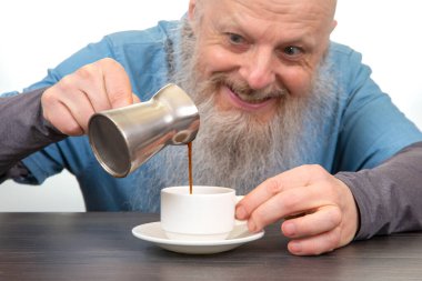 Kırsal sabah mutluluğu: uzun sakallı yaşlı beyefendi ev yapımı iç açıcı bir kahvaltı hazırlarken sırıtıyor.