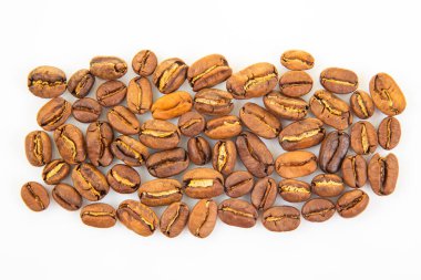 Kavrulmuş kahve çekirdeklerinin yüksek çözünürlüklü görüntüsü, beyaz arka plandaki sıcak kahverengi gölgeleri ve doğal çatlakları vurguluyor. Kafein görselleri için uygun.