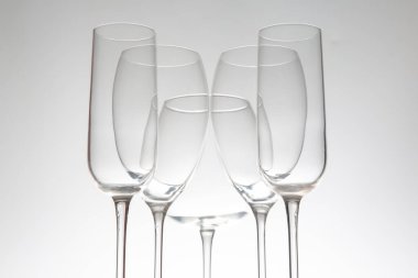 Zarif saplı beş sıra boş şarap kadehi, parlak bir masaya mükemmel yansıyor, konukseverlik, etkinlik veya şarapla ilgili görseller için ideal..