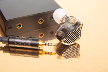 Kulaklığın yakın çekimi, 3.5 mm 'lik altın kaplama bir fiş, ve parlak altın arka planda bir müzik çalar, ses teknolojisi ve ürün çekimleri için mükemmel.