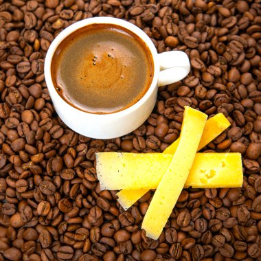Peynir çubukları ve kahve çekirdekleri ile beyaz fincan taze espresso kahve. Kahve kahvaltısı.