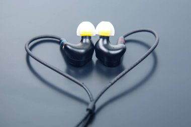 Çıkarılabilir kablolu yüksek kaliteli kulak monitörleri, siyah kulaklıklar, kulak uçları ve 3.5 mm 'lik altın kaplamalı kriko. Odiyofiller ve müzisyenler için ideal. Parlak gri bir arkaplanda izole edilmiş.
