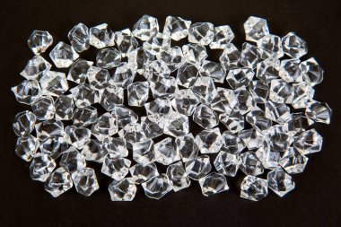 Karanlık bir yüzeyde şeffaf kristaller parıldıyor, göz kamaştırıcı bir efektle ışığı yansıtıyor, şenlikli, lüks veya takıdan esinlenilmiş bir sahne yaratmak için ideal..