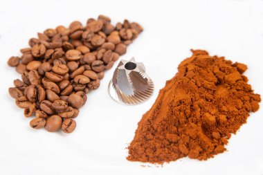 Kavrulmuş kahve çekirdekleri ve beyaz arka planda öğütücü kahve dönüşüm sürecini gösteriyor. Yemek fotoğrafçılığına uygun..