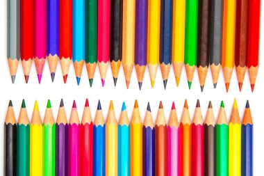 Beyaz bir arkaplan karşısında parlak bir şebeke şeklinde katmanlı renkli kalemler. Sanat materyallerini, eğitim temalarını veya yaratıcı proje fikirlerini resmetmek için harika.