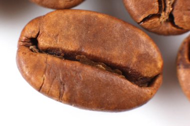 Kavrulmuş kahve çekirdeğinin yüksek çözünürlüklü görüntüsü doğal çatlaklarını ve parlak kaplamasını gösteriyor. Kahve endüstrisi promosyonları ya da yemek tarifi siteleri için mükemmel.