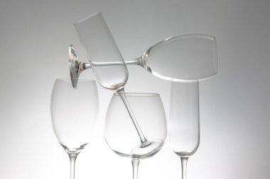 İnce saplı beş şarap kadehinden oluşan şık bir sıra, yansımaları parlak bir masa üzerinde çarpıcı bir etki yaratıyor, modern yemek ve şarap estetiği için ideal..