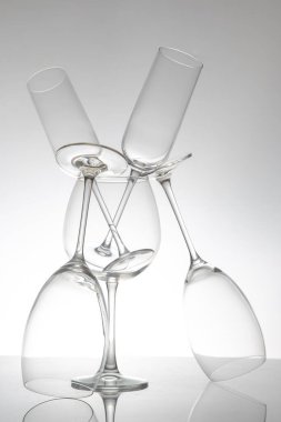 İnce saplı beş şarap kadehinden oluşan şık bir sıra, yansımaları parlak bir masa üzerinde çarpıcı bir etki yaratıyor, modern yemek ve şarap estetiği için ideal..