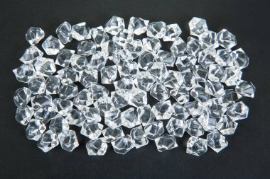 Karanlık bir yüzeyde şeffaf kristaller parıldıyor, göz kamaştırıcı bir efektle ışığı yansıtıyor, şenlikli, lüks veya takıdan esinlenilmiş bir sahne yaratmak için ideal..