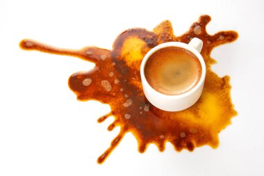 Siyah espresso beyaz bir bardaktan dökülür, temiz bir arkaplanda soyut bir kahverengi leke oluşturur, günlük karmaşadaki güzelliği vurgular.