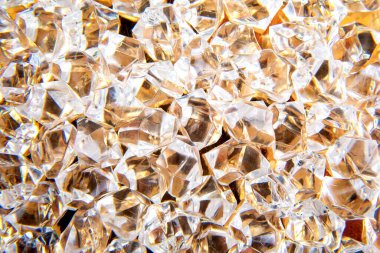 Parlak kristaller altın bir yüzeye saçılmış, ışığı güzel yansıtıyor, lüks ve zarafet temalı tasarımlar veya şenlikli dekorasyonlar için mükemmel..