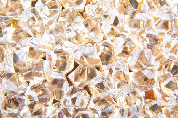 Parlak kristaller altın bir yüzeye saçılmış, ışığı güzel yansıtıyor, lüks ve zarafet temalı tasarımlar veya şenlikli dekorasyonlar için mükemmel..