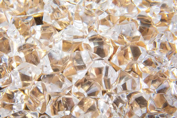 Parlak altın bir zemin üzerinde şeffaf mücevher benzeri kristaller koleksiyonu göz alıcı ve zengin bir estetik yaratıyor. Mücevher ya da tatil dekorasyonu için ideal..