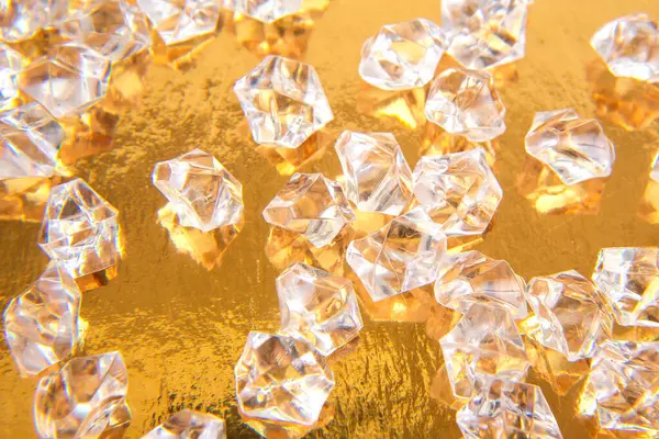 Parlak altın bir zemin üzerinde şeffaf mücevher benzeri kristaller koleksiyonu göz alıcı ve zengin bir estetik yaratıyor. Mücevher ya da tatil dekorasyonu için ideal..