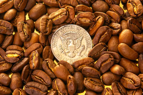Kavrulmuş kahve çekirdekleri ve altın yansıtıcı arka planda bir ölçek için Amerikan parasıyla zengin kahverengi renkleri ve dokuları sergileniyor. Kahve ve boyut karşılaştırması için mükemmel..