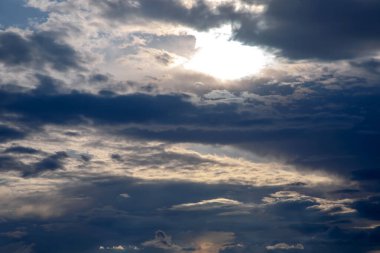 Yoğun kara bulutlar ve ışık saçan güneş ışığıyla görkemli bulutlar. Güçlü bir atmosferik etki arayan doğa severler, hava meraklıları ve sanatsal projeler için idealdir..