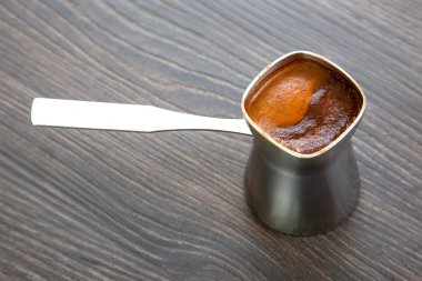 Ahşap zemin üzerinde aromatik Türk kahvesi bulunan metal bir Cavve 'in kırsal görüntüsü. Kafe menüleri, kahve severler ya da etnik yemek promosyonları için mükemmel..