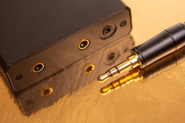 Pırıl pırıl altın bir yüzeyde 3.5 mm 'lik ses bağlantılarının detaylı görüntüsü, teknoloji, müzik ve ses aksesuarları için harika.