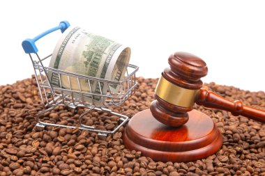 Yasal ve ticari temalar bir tokmak, bir alışveriş arabasında 100 dolarlık banknot ve kahve çekirdekleri, ticaret yasaları ve mali işlemlerin ön plana çıkarılması ile çarpışıyor