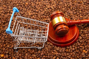 Minyatür bir alışveriş arabası ve kavrulmuş kahve çekirdekleri üzerinde tokmakla ticaret ve adaleti temsil eden sembolik bir hayat. Yasal, iş veya kahve endüstrisi kavramları için ideal.