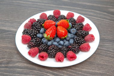 Ahududu, yaban mersini ve böğürtlen beyaz tabakta. Vitamin ve Diyet Yemekler