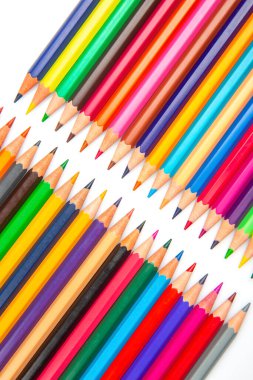 Beyaz arkaplanda sıralanmış renkli renkli kalemlerin yakın plan çekimi. Sanat materyallerini, okula geri dönmeyi veya yaratıcı ilhamı teşvik etmek için mükemmel..