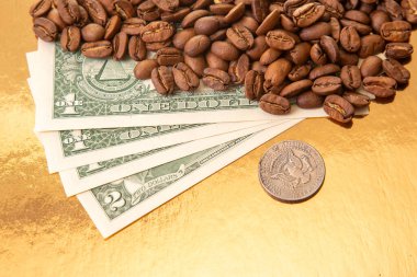 Amerikan doları banknotları, kahve üretimi, ticaret ve finansal refah arasındaki bağlantıyı vurgulayan, altın arka planda kavrulmuş kahve çekirdekleriyle kısmen kaplıdır..
