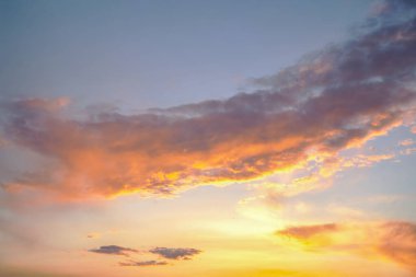 Karanlık ve aydınlık bulutlar çarpıcı bir günbatımı gökyüzünde harmanlanır. Güneşin altın parıltısı bulutların kenarlarını hafifçe aydınlatır, rüya gibi ve karamsar bir etki yaratır..