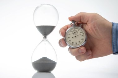 mechanical stopwatch and hourglass in hand. Time part precision. Measuring the speed interval with a watch