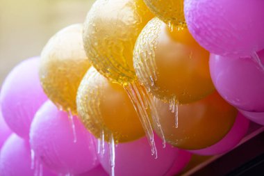 Donmuş renkli şişirilebilir tatil toplarının üzerindeki buz saçakları. Kış mevsimi. sokak içi ayrıntıları