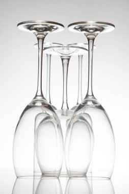 Farklı tasarımları olan beş boş şarap kadehinden oluşan şık bir koleksiyon, yansımaları parlak bir yüzey üzerinde ayna etkisi yaratıyor, şarap tatma temaları için harika..