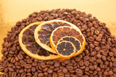 Altın yansıtıcı yüzey kahve çekirdekleri ve kurutulmuş portakal dilimlerine ev sahipliği yapar. Aromatik besin bileşimleri için mükemmel bir atış. Kahve aroması ve turunçgiller.