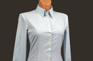 Açık mavi çizgili uzun kollu bir gömlek bir mankenin üzerinde sergilenir..