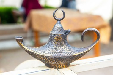 Türkiye 'de canlı bir pazarda, karmaşık desenler içeren güzel işlenmiş bir pirinç lamba sergileniyor. Lamba, yerel satıcıların renkli tezgahları ve canlı atmosferinde göze çarpıyor..